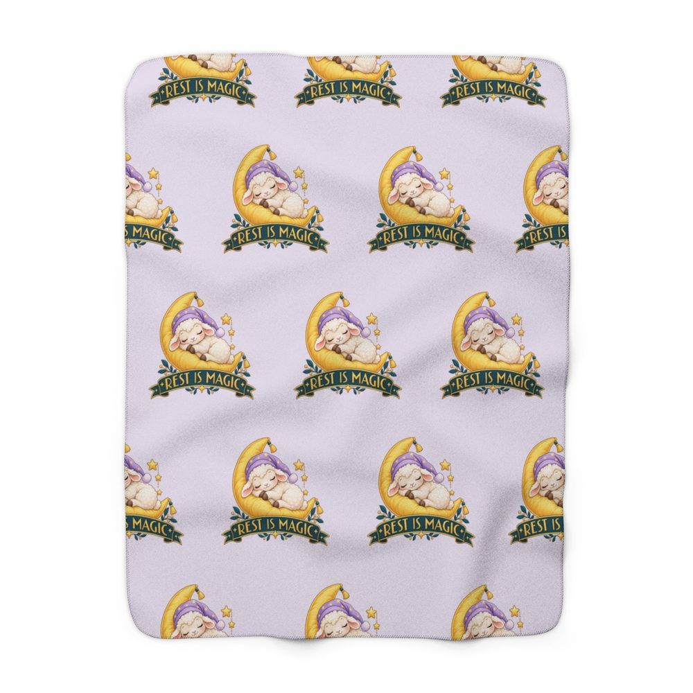 Rest Is Magic sherpa fleece blanket in lavender, covered in a repeating sleepy white lamb in a nightcap resting on a yellow crescent moon above a green banner reading Rest Is Magic