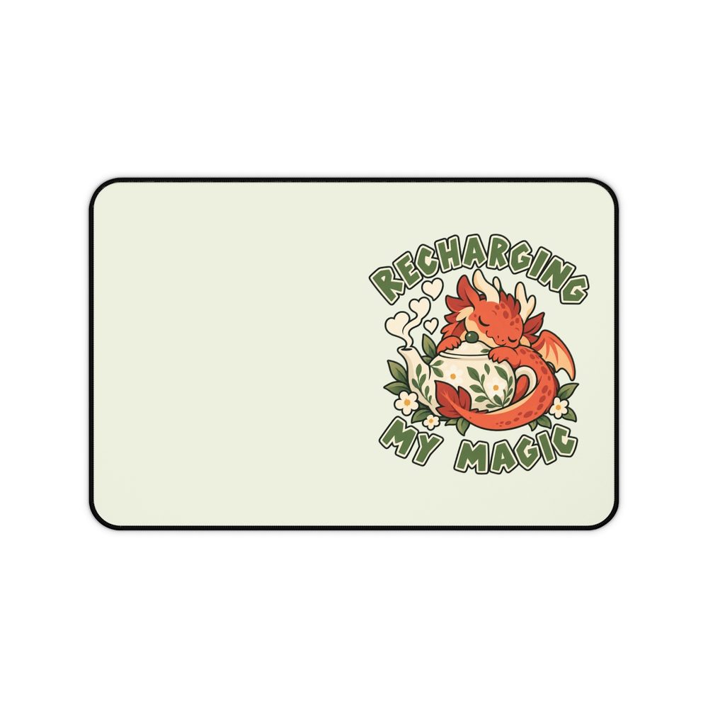 Tea Dragon desk mat, a pale mint 12 by 18 inch mat with a black stitched edge, printed with a red dragon curled around a white teapot and leaves under the words Recharging My Magic