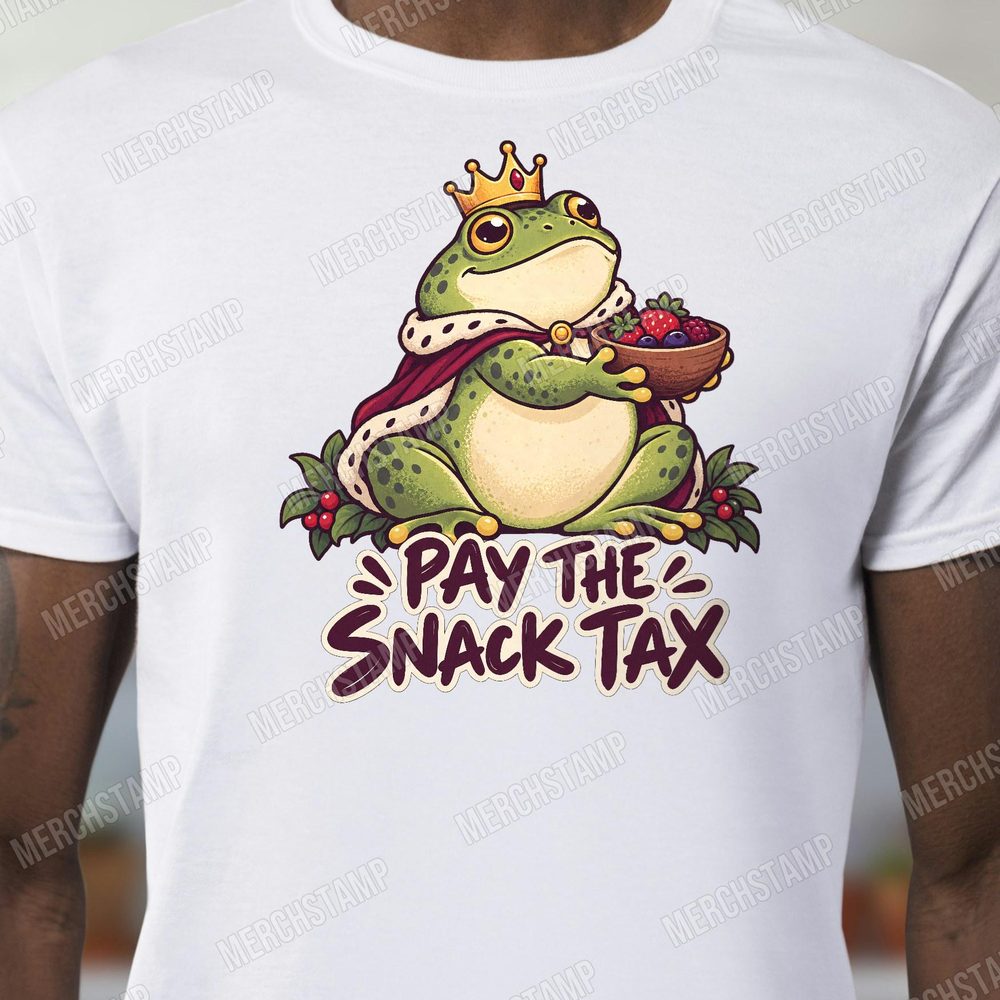 Pay The Snack Tax PNG design shown on a white t-shirt, a plump crowned frog in a red royal cape holding a bowl of berries above the words Pay The Snack Tax