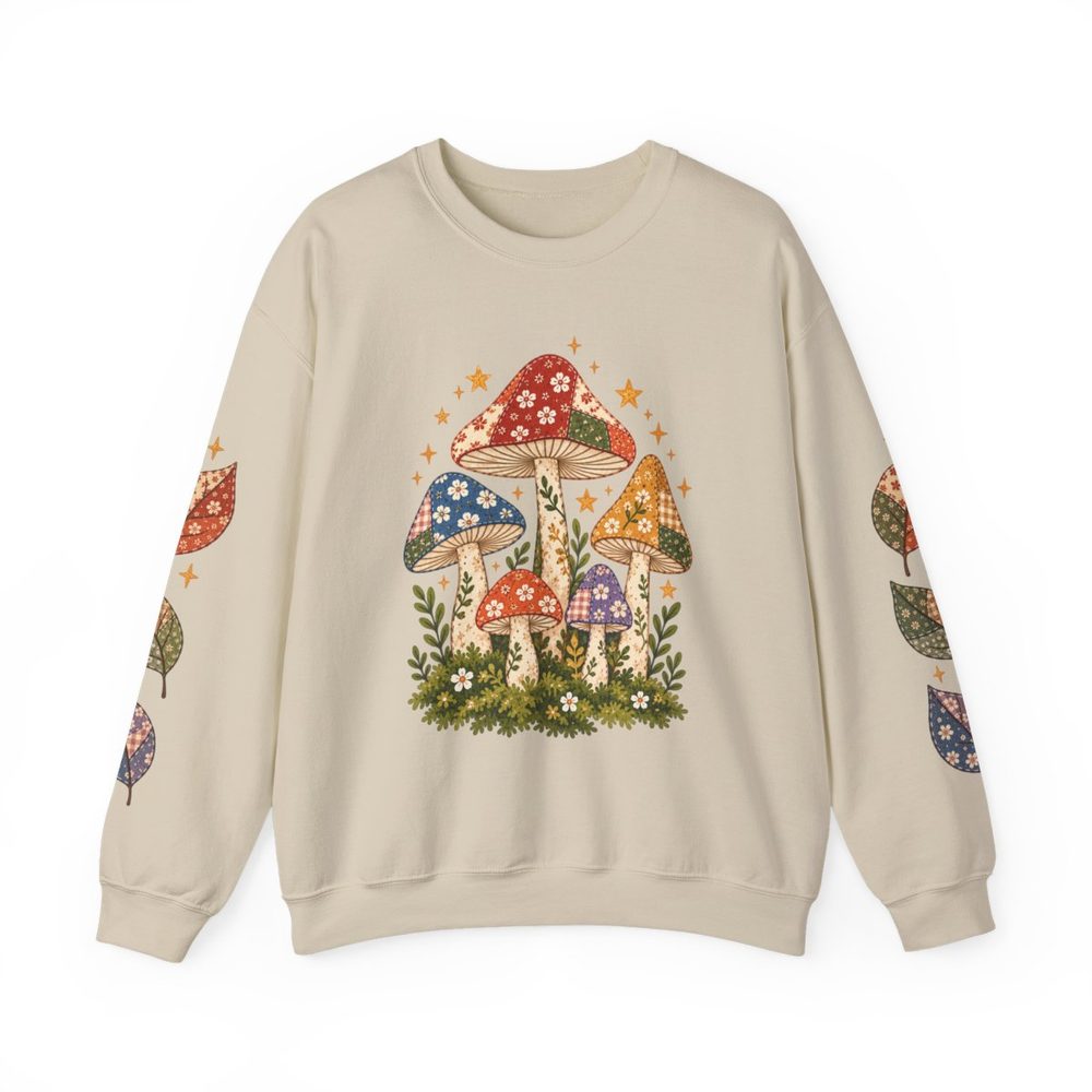 Patchwork Mushroom crewneck sweatshirt in sand, a cluster of patterned, patchwork-style mushrooms on a mossy base on the front with matching prints down both sleeves