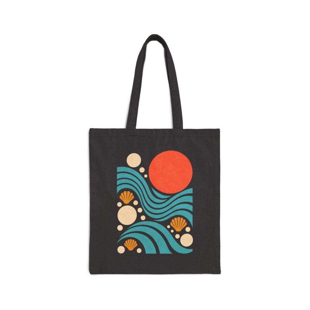 Geometric Ocean tote bag in black cotton canvas, printed with teal wave arcs, a coral sun and cream shell shapes in a geometric layout